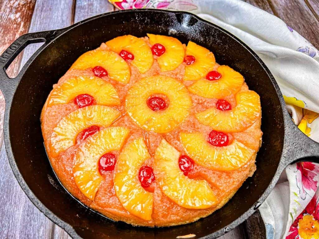 A Pineapple Upside Down Cake on a black cake pan.