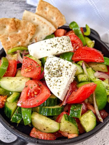 Horiatiki Salad in a black bowl.