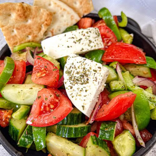 Horiatiki Salad in a black bowl.