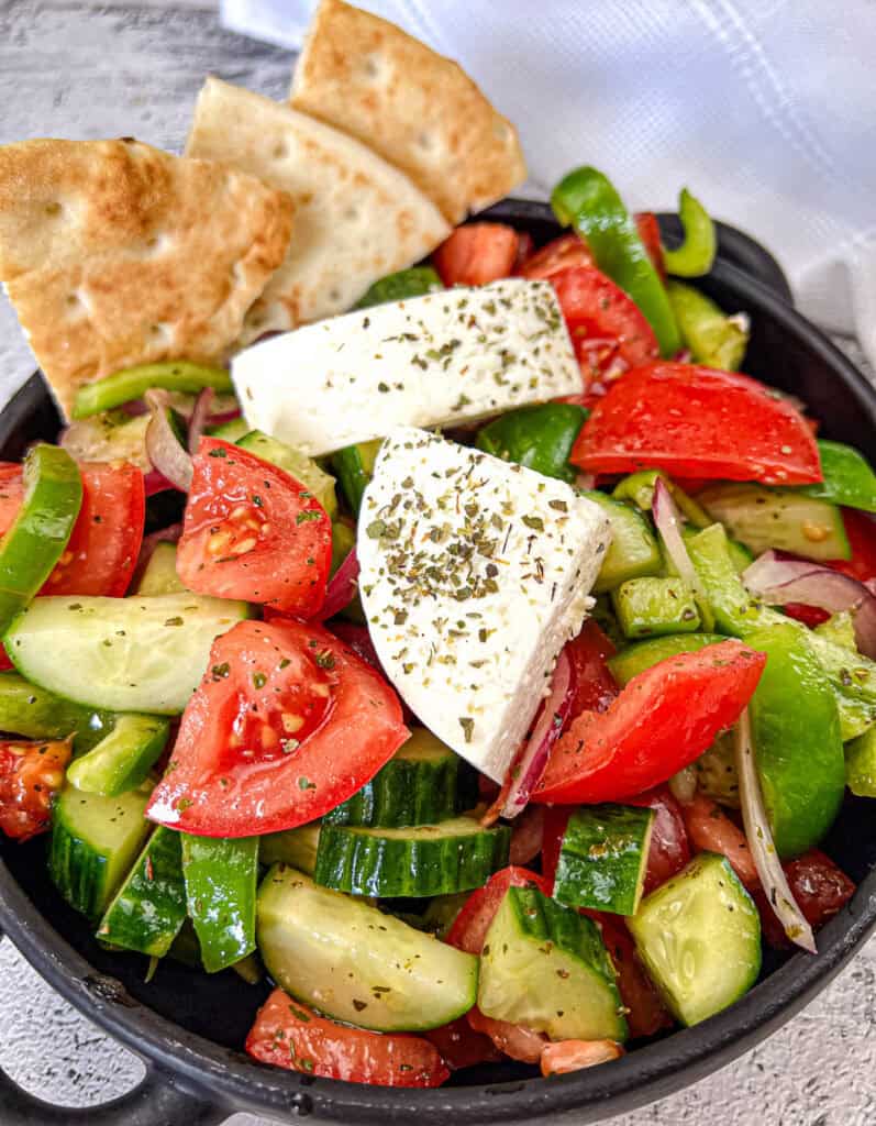 Horiatiki Salad in a black bowl.