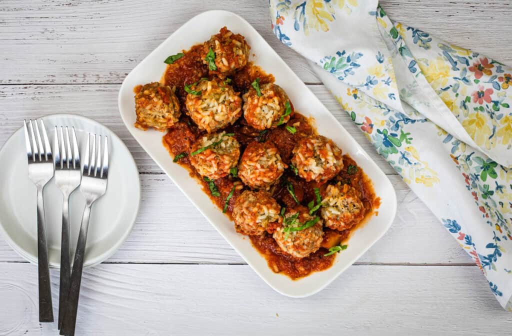 Top-down shot of Slow Cooker Porcupine Meatballs on a white plate.