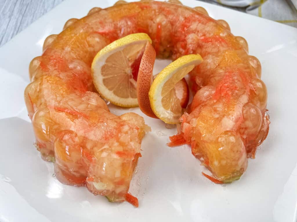 Sunshine salad with slices of oranges in the center served on a white plate. on a white plate.