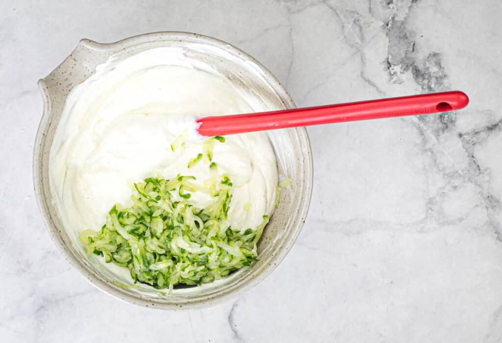 Place the cucumbers in a medium bowl, then add Greek yogurt, minced garlic, olive oil, and lemon juice.