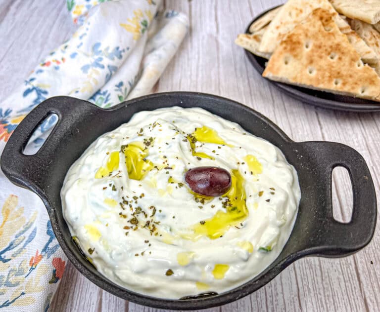 Tzatziki sauce served in a black bowl.
