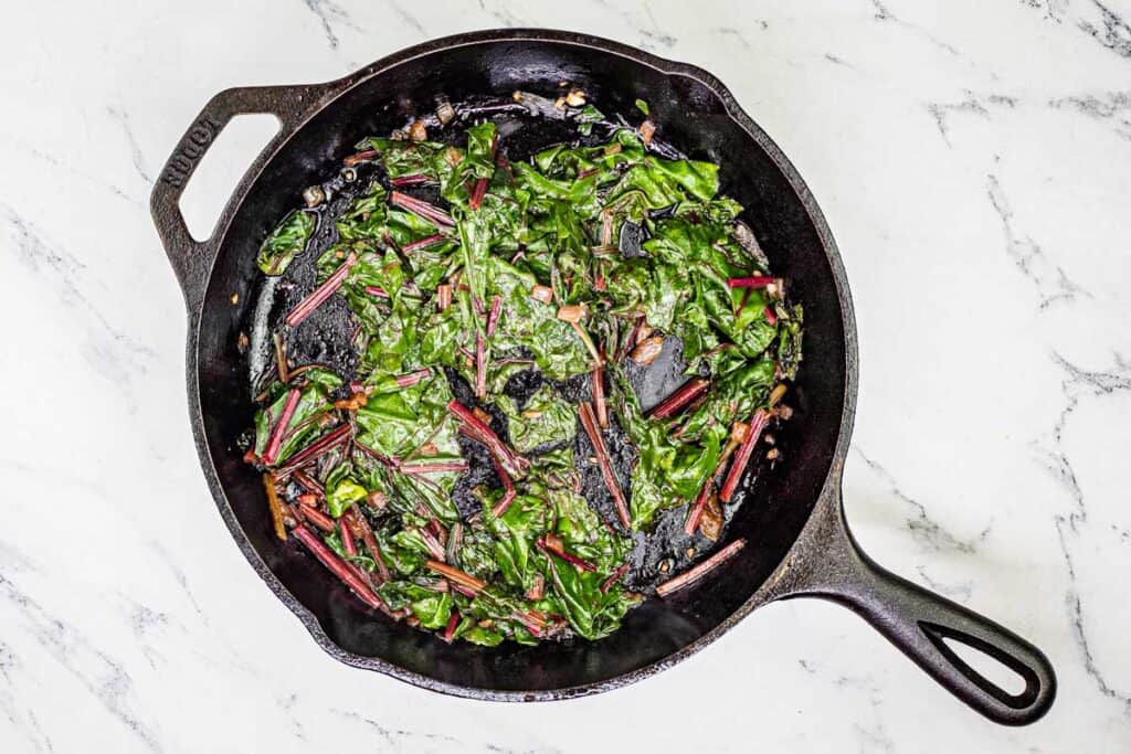 Cook for 5-6 minutes, stirring frequently, until the leaves and stems are tender.