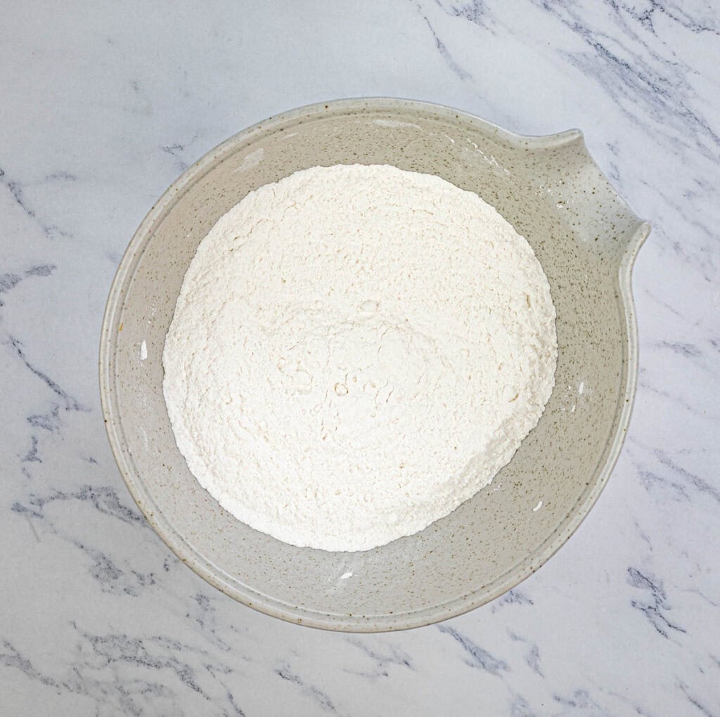 Mix flour, sugar, baking powder, lemon zest, and salt in a large bowl.