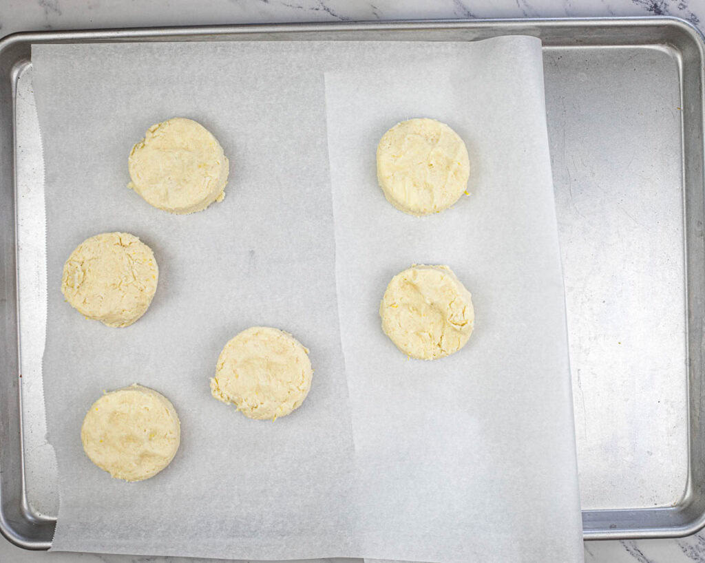 Cut biscuits with a round cutter and place on a parchment-lined baking sheet.