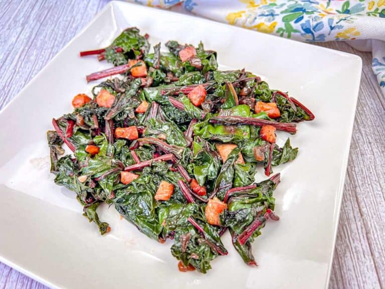 Sautéed beet greens with pancetta on a white plate.
