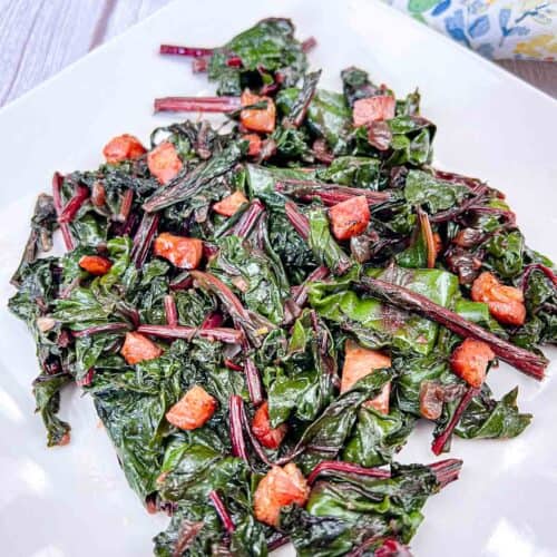 Sauteed Beet Greens with Pancetta served on a white plate.