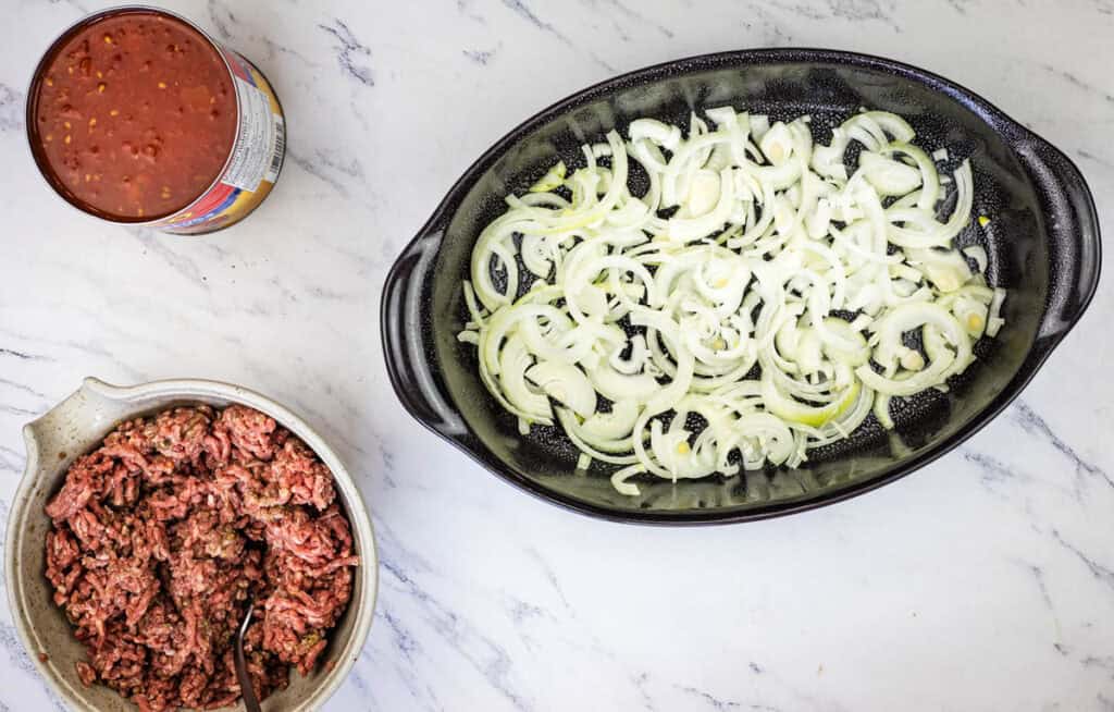 Layer the sliced onion into the bottom of the casserole dish.