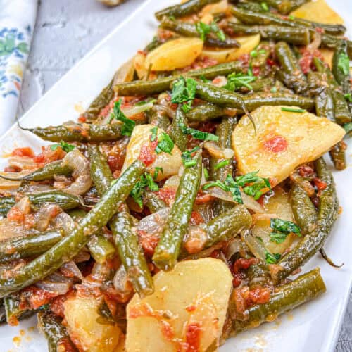 Greek green beans on a white plate.