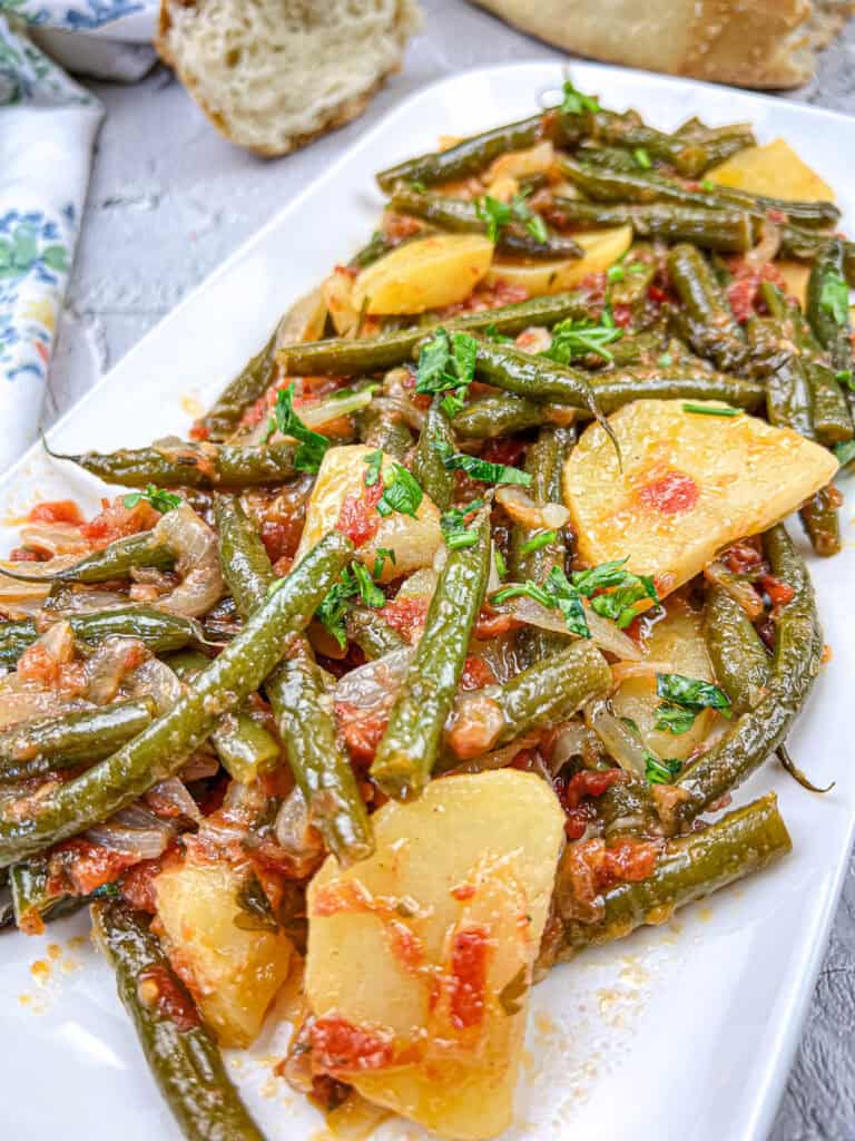 Greek green beans on a white plate.