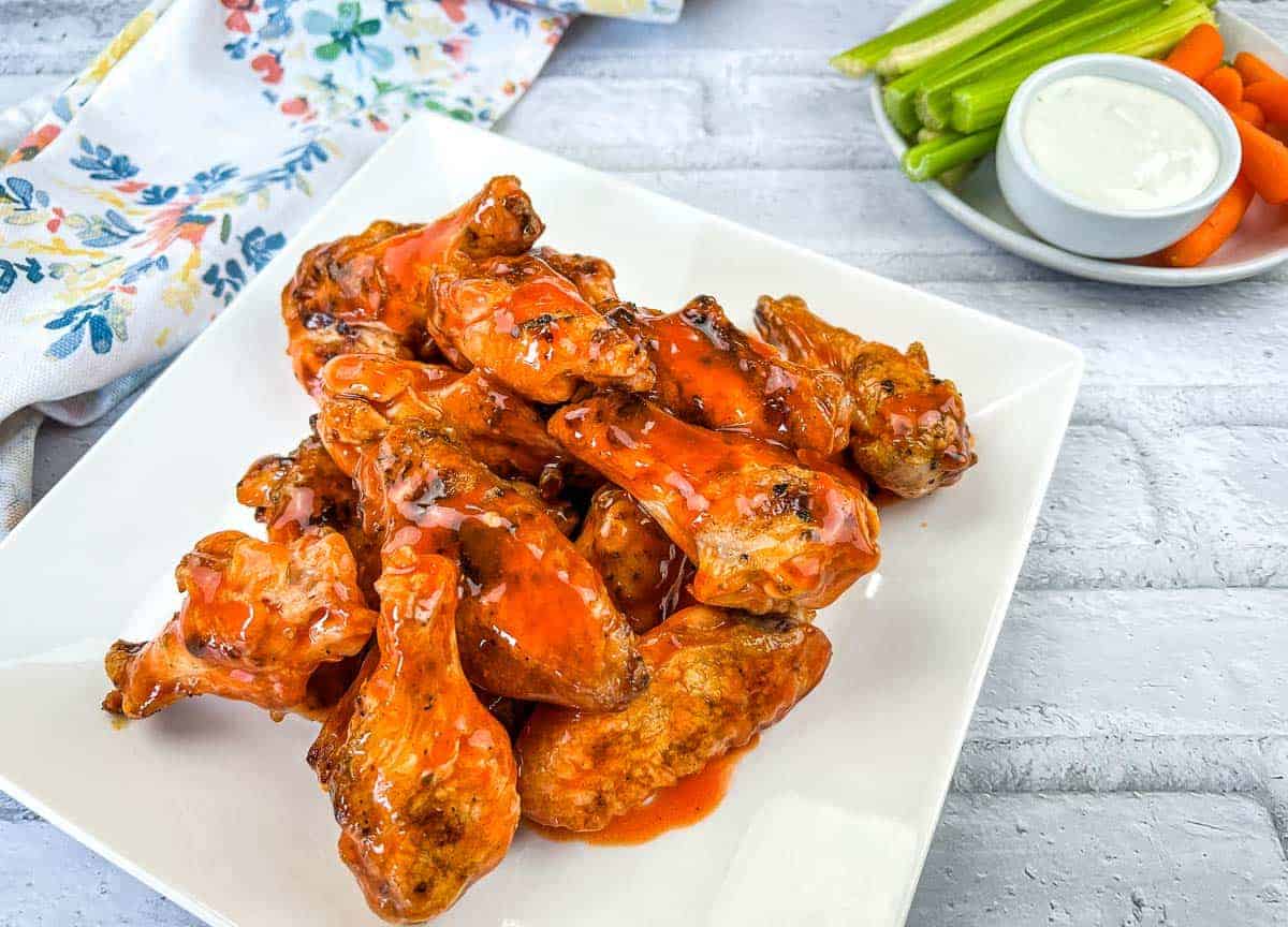Grilled Chicken Wings with Buffalo Sauce on a white square plate.