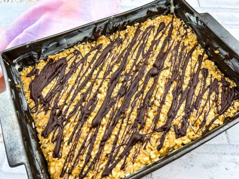 Molly bars in a baking dish with chocolate drizzled on top.