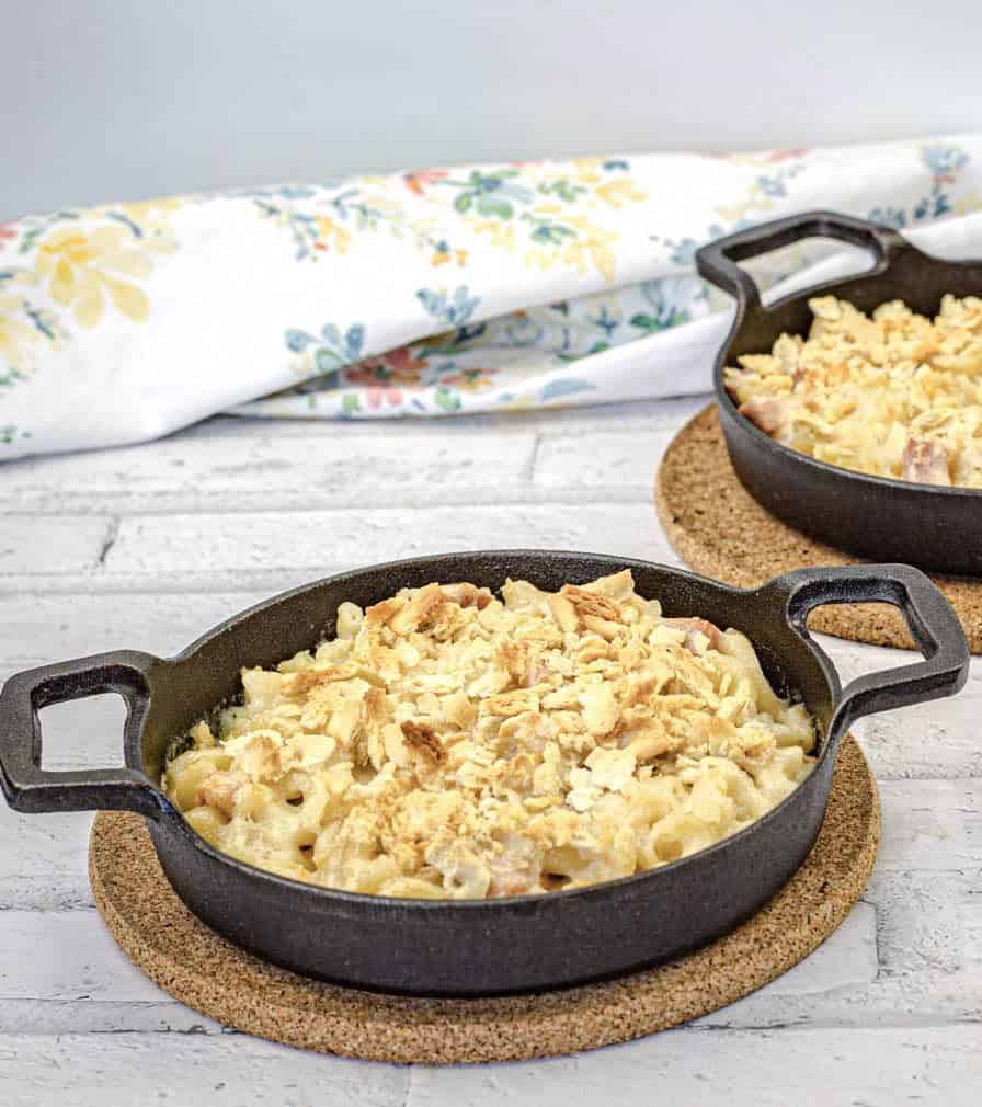 Two mac & cheese on a black dish.