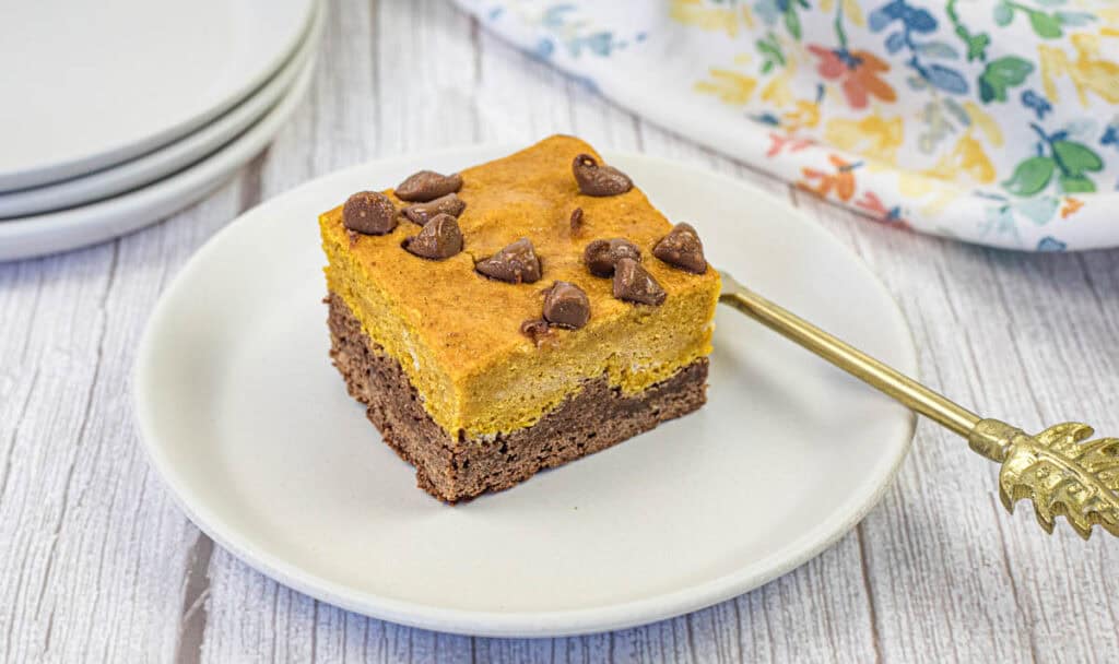 One piece of pumpkin brownie on a white plate.