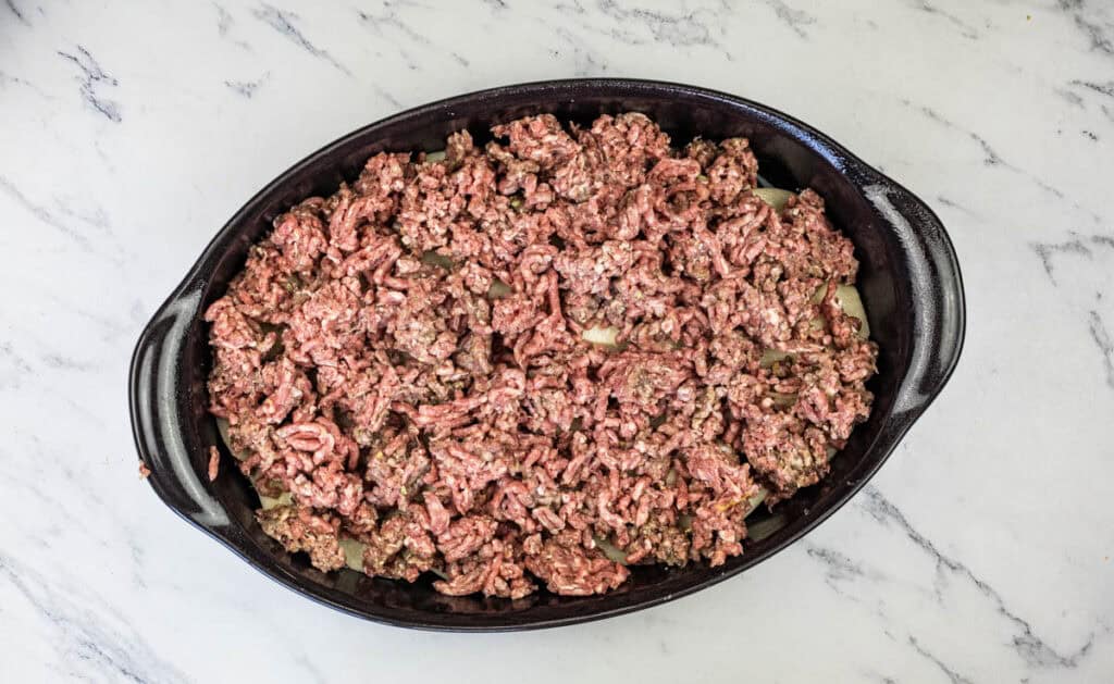 Crumble the ground beef and add it on top of the potatoes in an even layer.