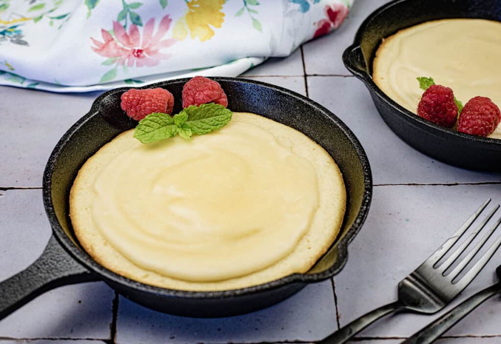 A pan of Grandma's buttermilk cake with raspberry on top.