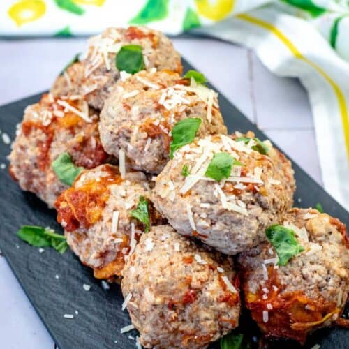 A pile of classic meatballs on a slate plate.