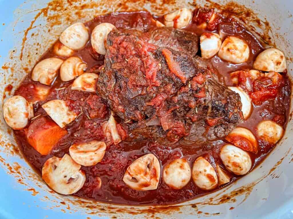 Transfer the vegetables, reduced red wine, and diced tomatoes to the slow cooker.