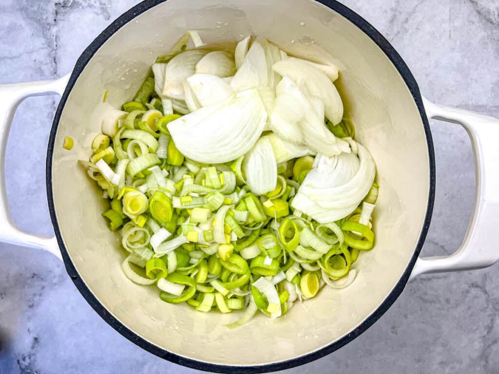 Add the sliced leeks and diced onion to the pot and saut&eacute;.
