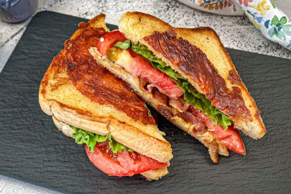 Two Texas BLT on a black slate plate.