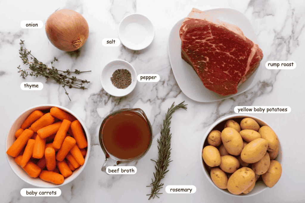 Ingredients for a pot roast including rump roast, yellow baby potatoes, baby carrots, an onion, thyme, rosemary, salt, pepper, and beef broth arranged on a marble surface.