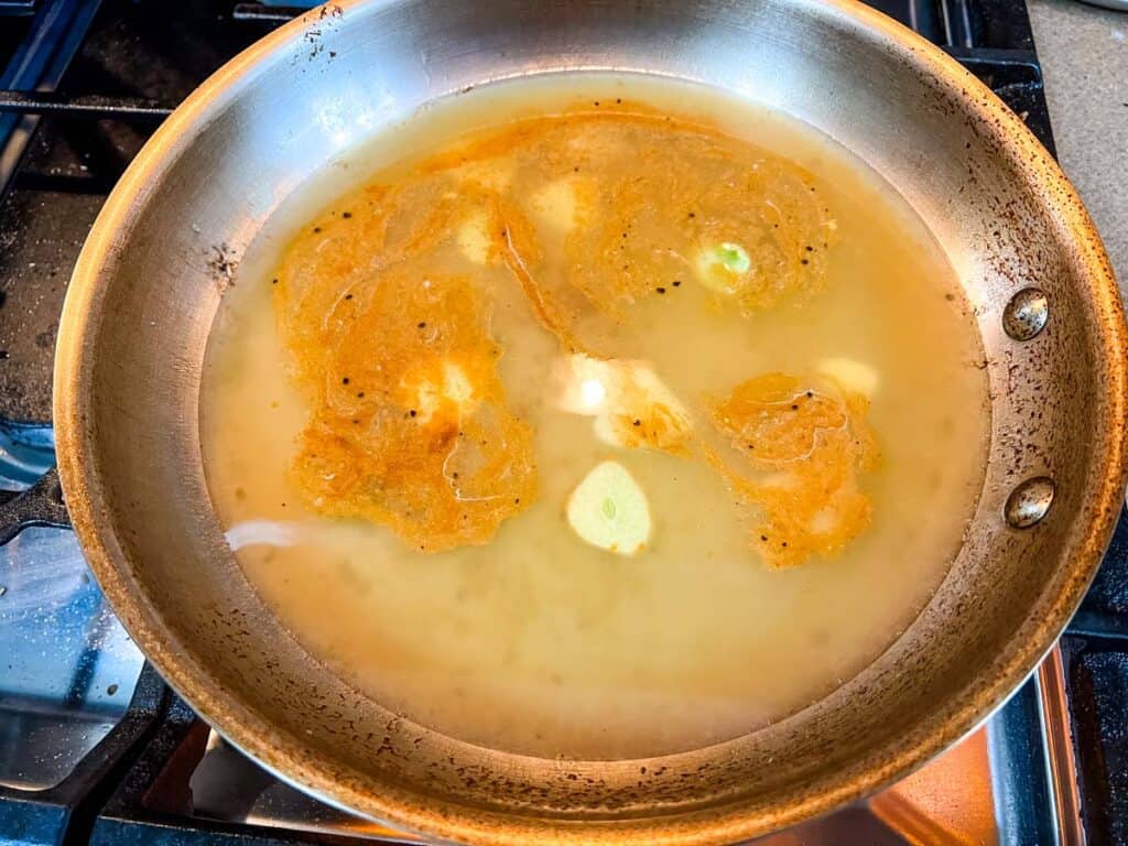 White wine and chicken broth in a skillet.