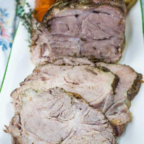 A half with a sliced Slow Cooker Herb-Crusted Pork Roast on a plate.