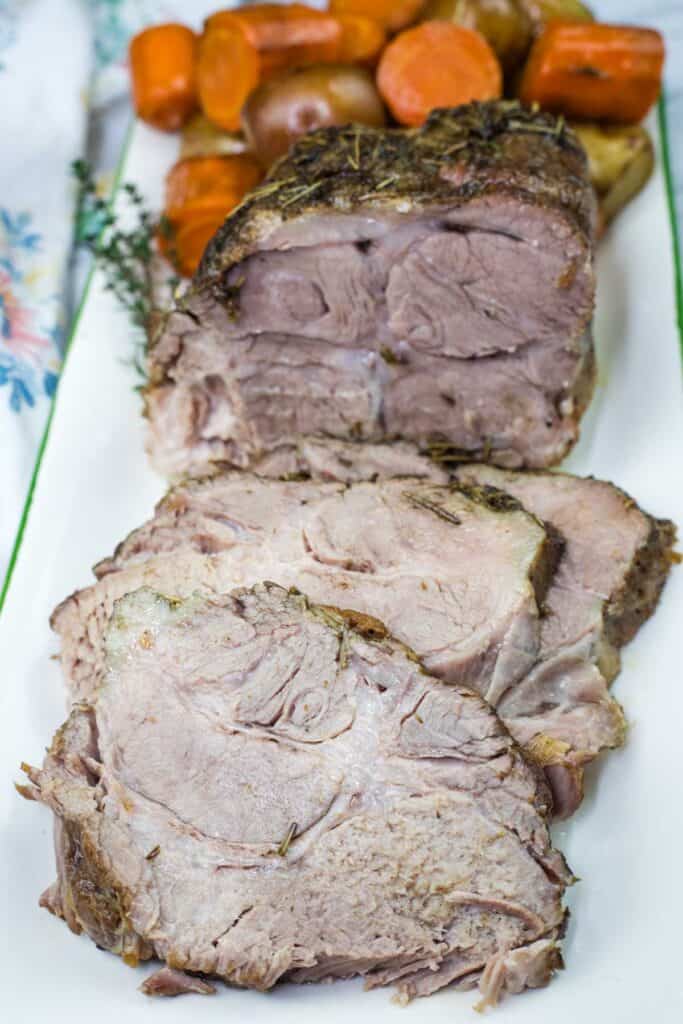 A half with a sliced Slow Cooker Herb-Crusted Pork Roast on a plate.