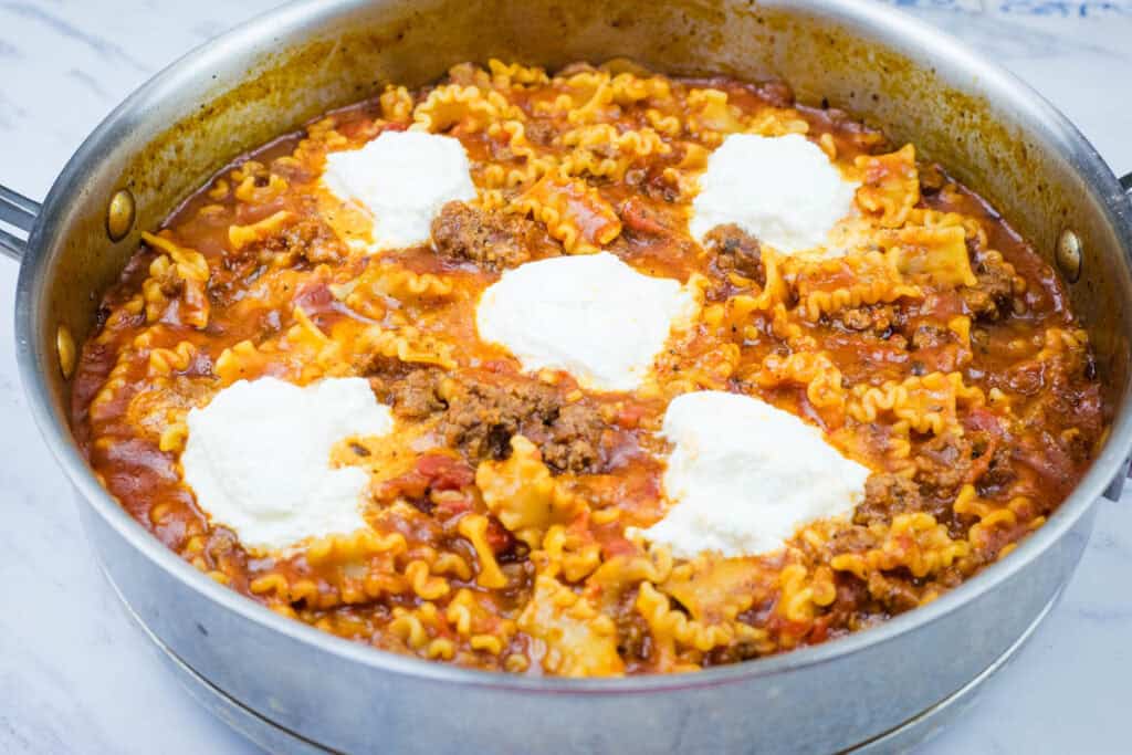 Lasagna Skillet with melted cheese on top in a white countertop.