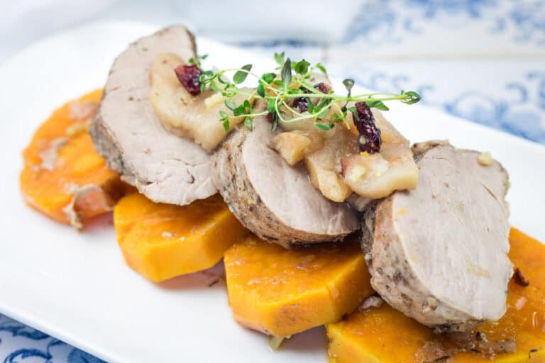 A serving of Slow Cooker Pork Tenderloin with Sweet Potatoes & Apples in a white platter.