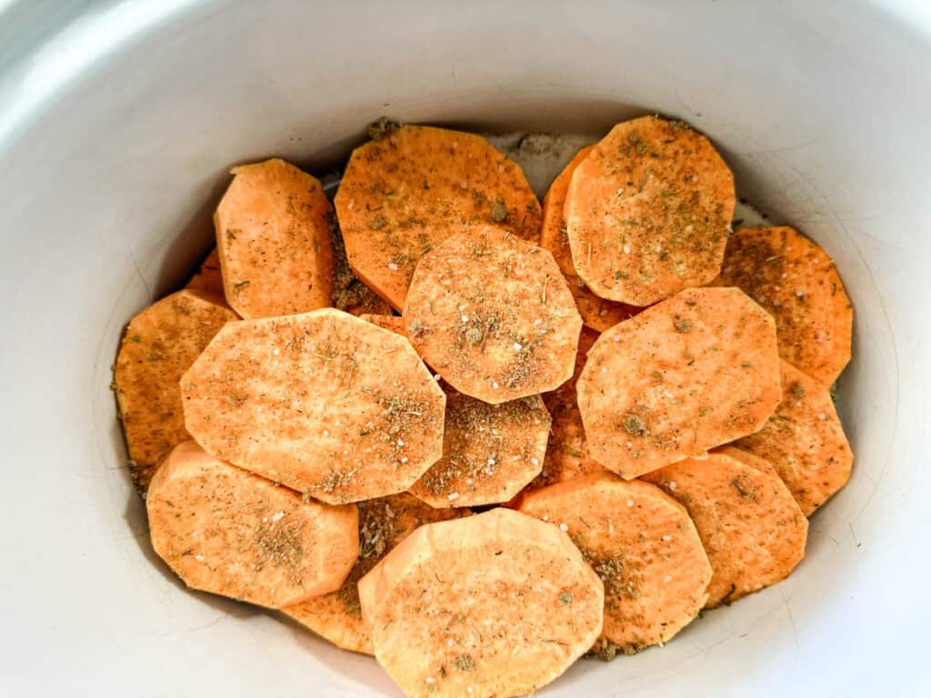 Sweet potato slices added to the mixture of brown sugar, thyme, salt, black pepper, cinnamon, nutmeg, ginger, and cayenne.