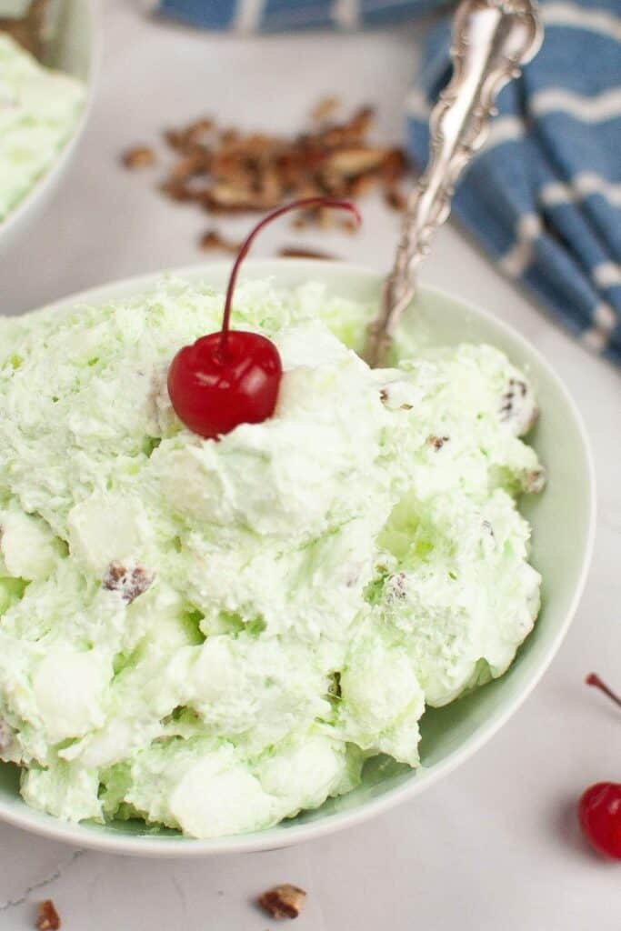 A bowl of Watergate Salad in a white bowl with a spoon.