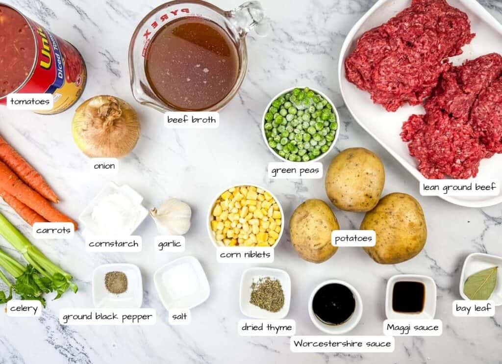 Ingredients for Mom's hamburger stew are arranged on a marble surface.
