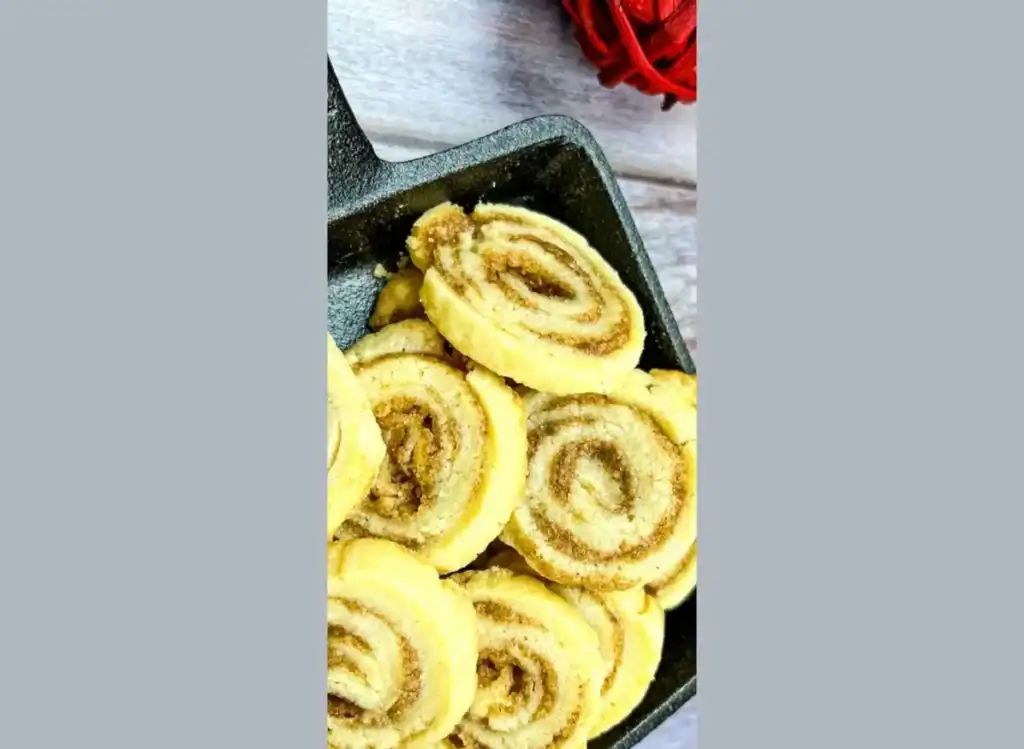 Cinnamon roll cookies in a skillet on a wooden table.