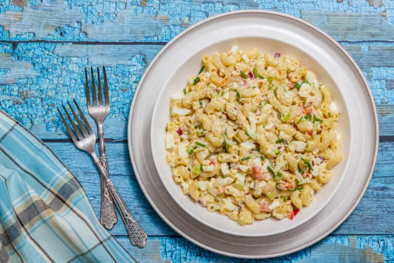 Plate of Deviled Egg Pasta Salad on a wooden table.