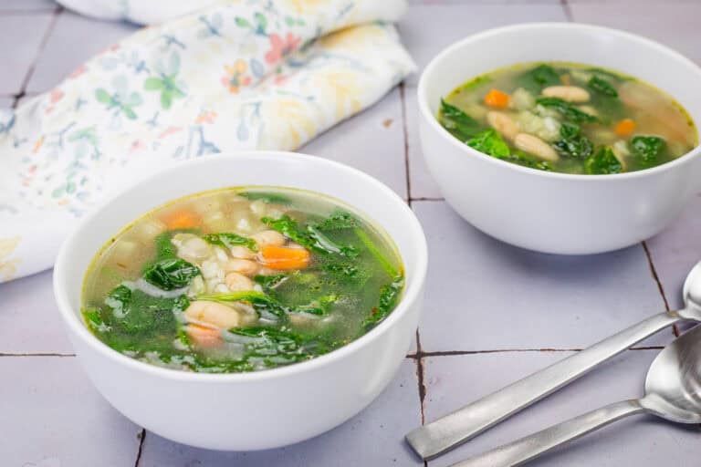 Two white bowls of Rice and White Bean Soup.