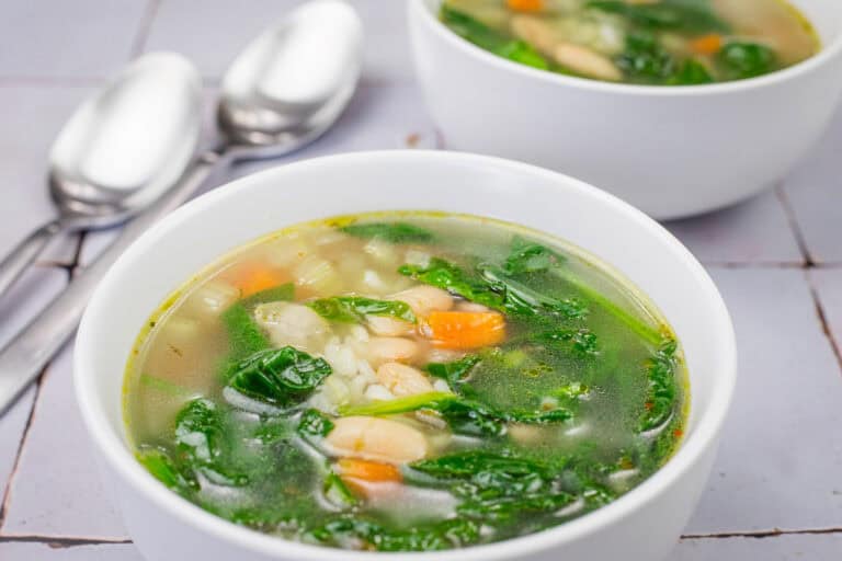 Bowl of Rice and White Bean Soup with spinach, carrots, and beans.