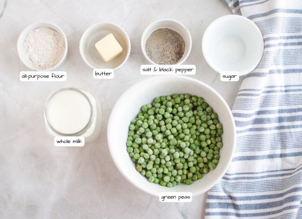 Overhead shot of ingredients for creamed peas, including green peas, whole milk, all-purpose flour, butter, salt, black pepper, and sugar, with labels.