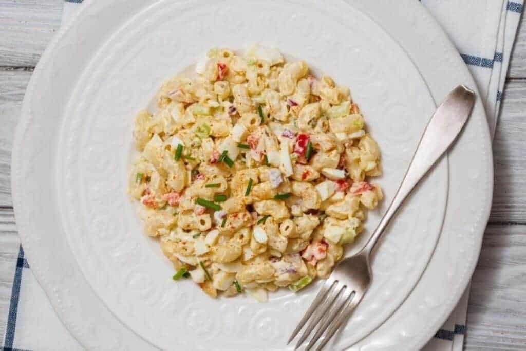 A plate of Deviled Egg Pasta Salad served with a fork on a white plate.