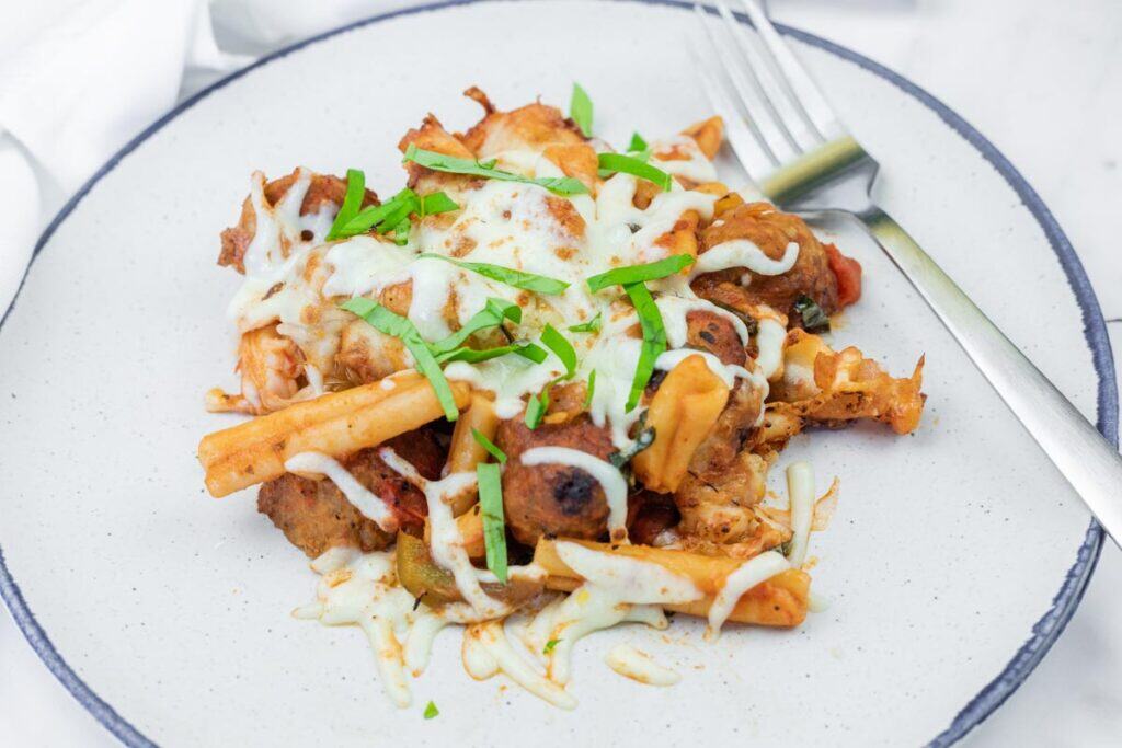 A round plate with a Mom's Meatball Casserole beside fork.
