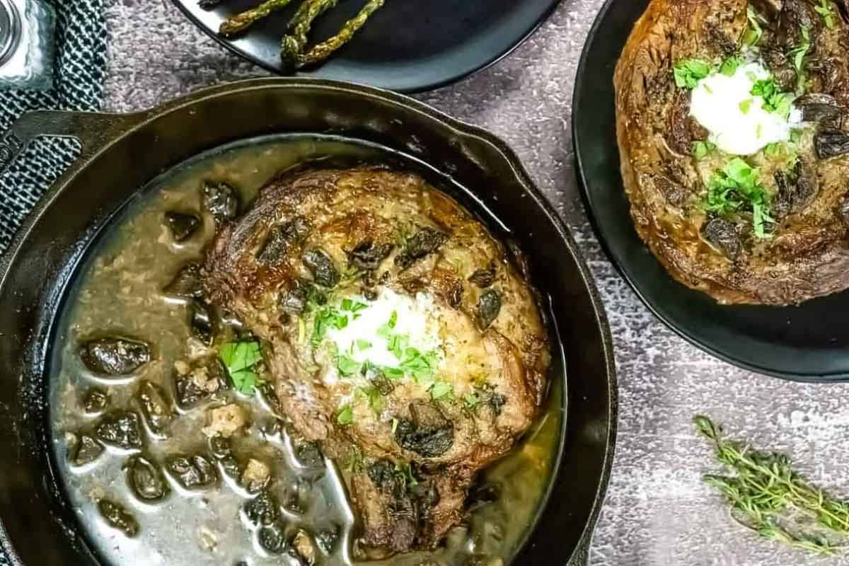 A Broiled Prime Rib & Roasted Asparagus, and a dollop of sauce in a cast-iron skillet with mushrooms, next to a plate of steak and roasted asparagus.